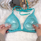 Clear silicone insert pair held at the cups of a turquoise swimsuit