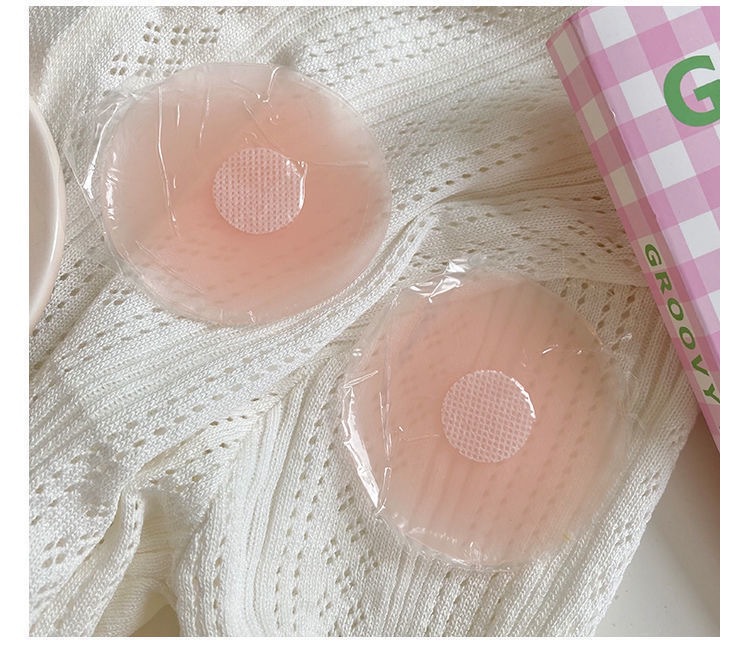 Flower-shaped pink adhesive cover pair on knit fabric