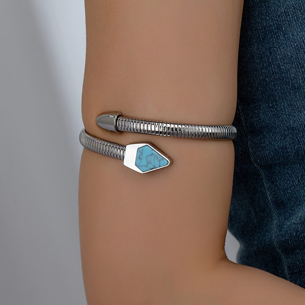 Blue-accent silver-colored ribbed arm cuff worn on the upper arm