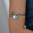 Blue-accent silver-colored ribbed arm cuff worn on the upper arm