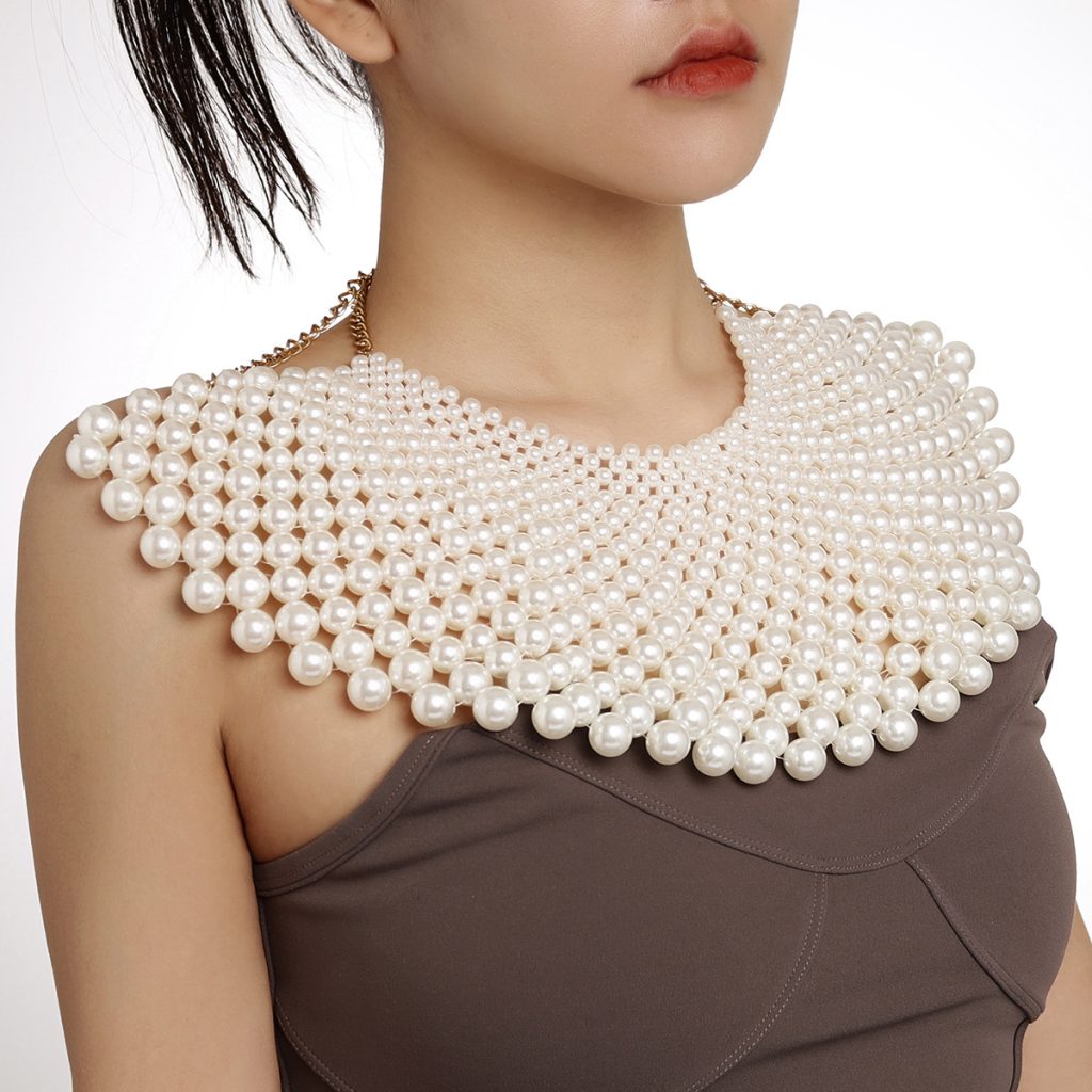 White graduated bead bib worn at the neckline
