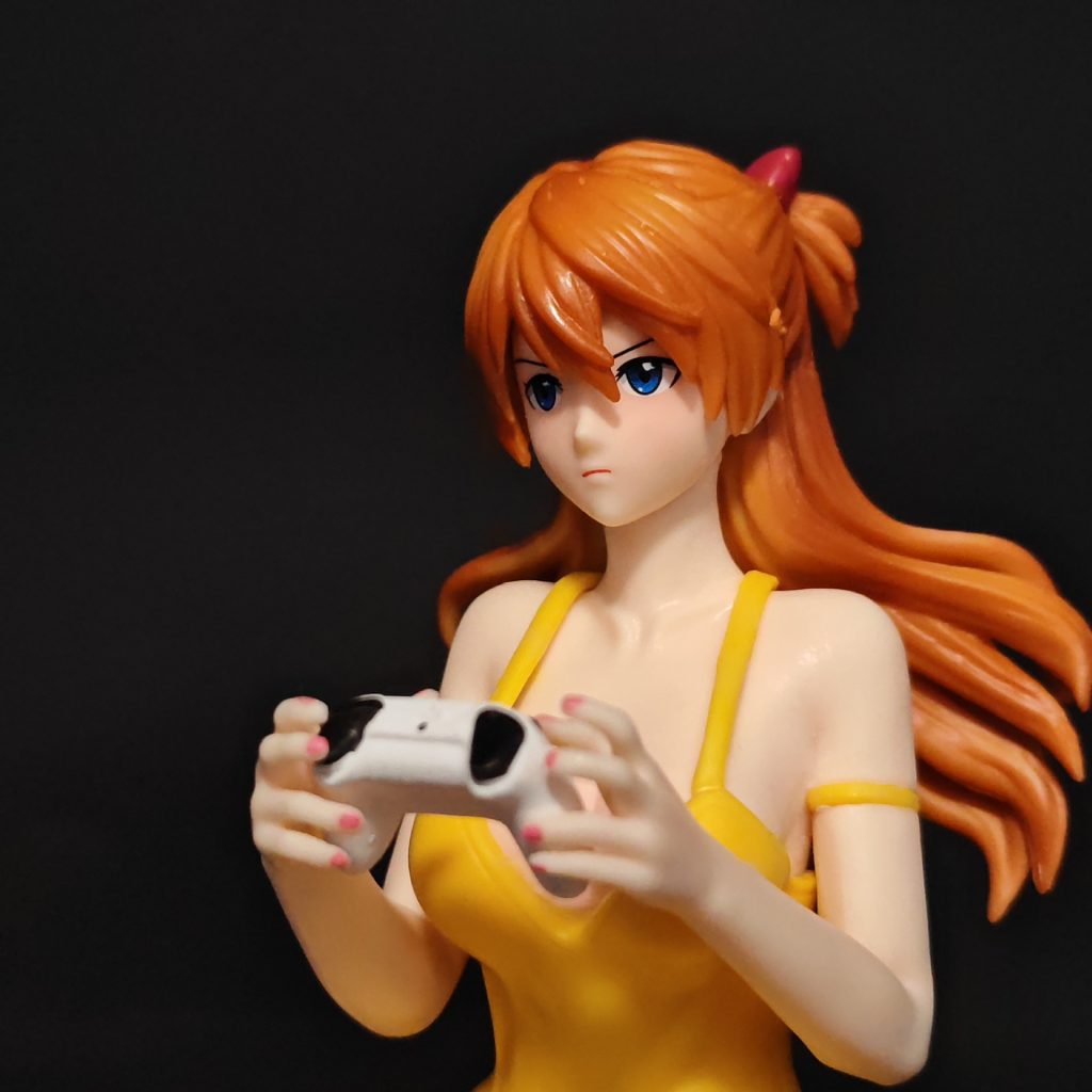 Close view of Asuka figure's blue eyes, orange hair and game controller
