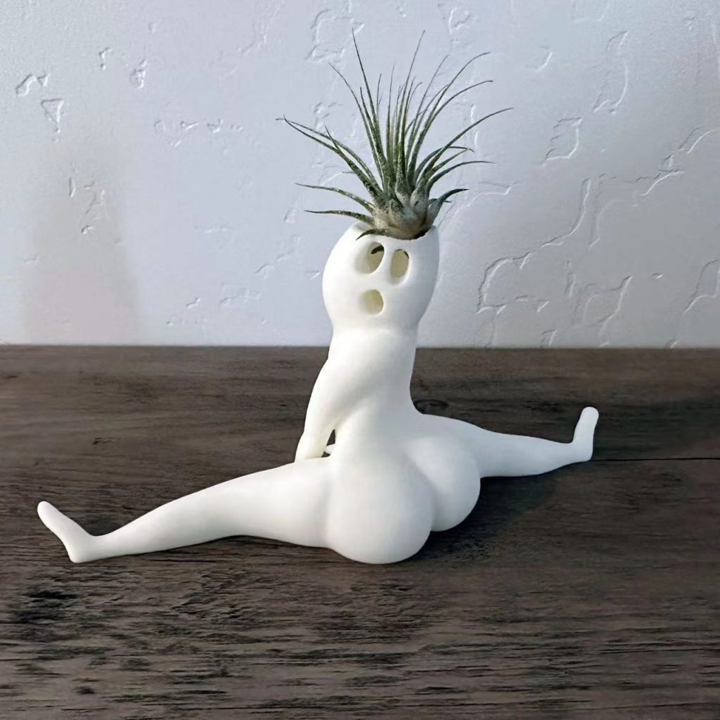 Side and rear angle of white split-pose planter on a tabletop
