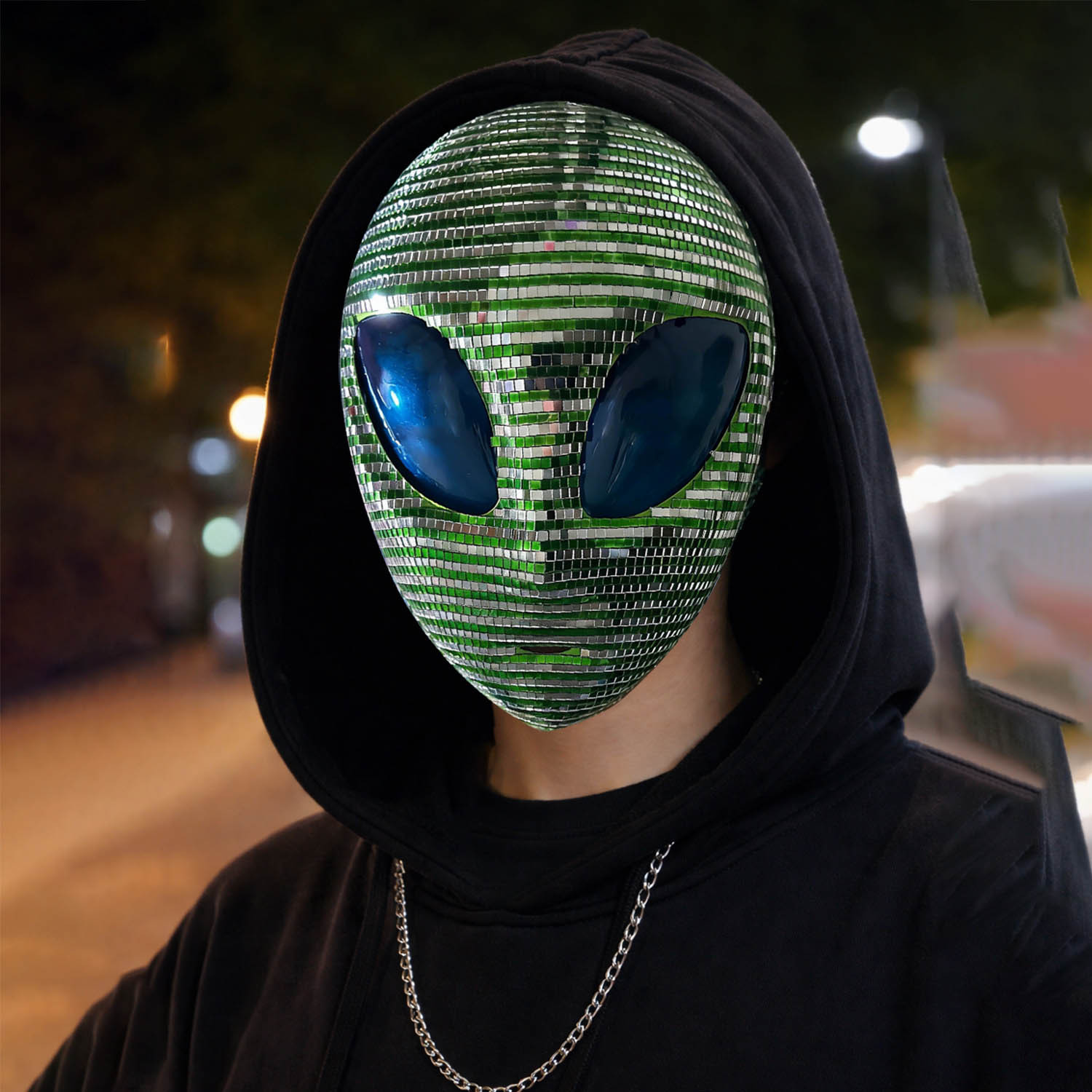 Green and silver alien mask worn with a black hood