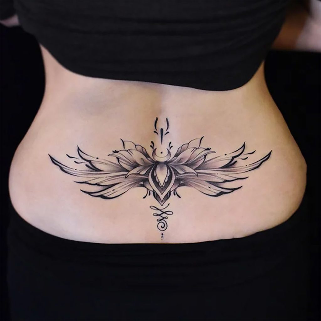 Black winged floral temporary tattoo across the lower back