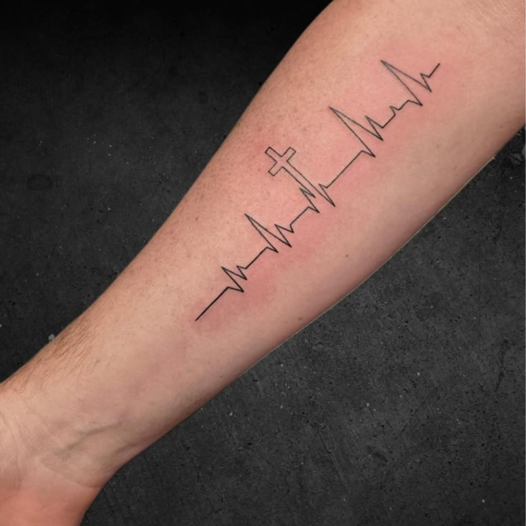 ECG cross tattoo shown along forearm
