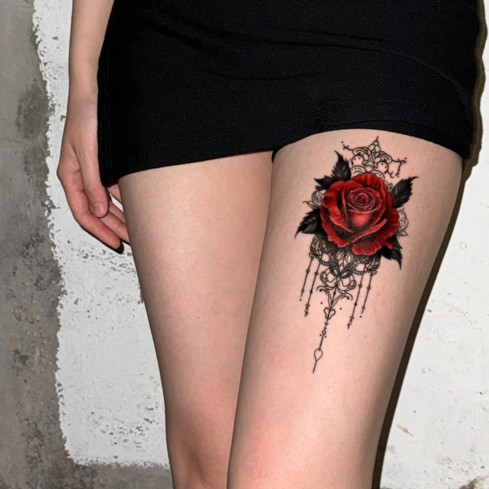 Red rose ornamental tattoo on upper leg