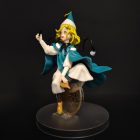 Side view of Coco figurine with teal cape and circular gold-patterned backdrop