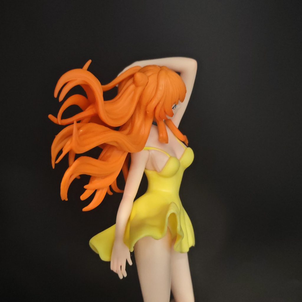 Back three-quarter close-up of Asuka's orange hair and yellow dress