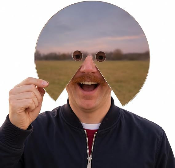 Person holding a reflective face prop in front of their face