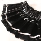 Close-up of glossy black pleats and contrasting white hem stripe