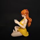 Left profile of seated Asuka figure showing her orange hair and yellow dress