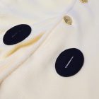 Cream cape front with buttons and dark oval accents
