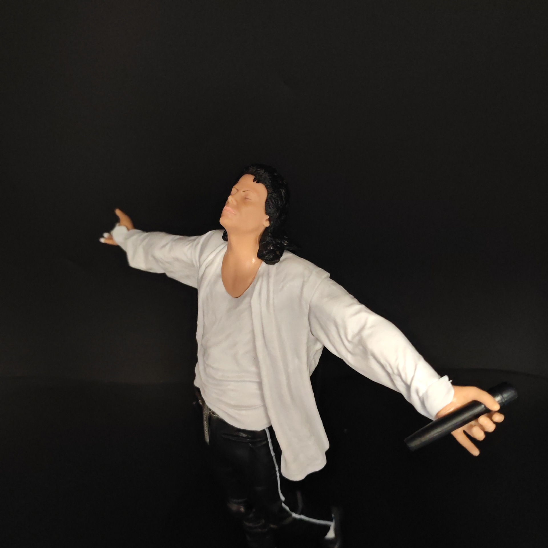 Singing pose figure with white shirt, microphone and black trousers