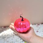 Pink mirrored disco pumpkin in hand with curved stem
