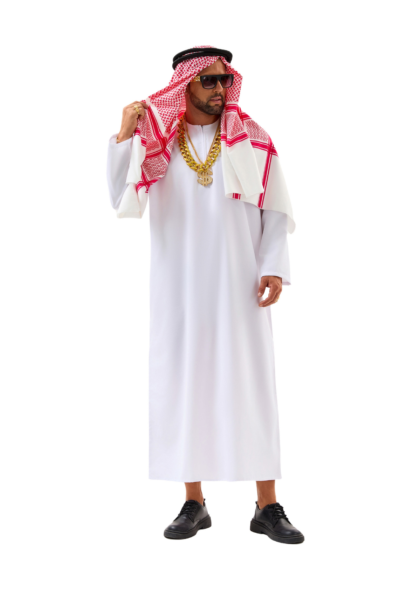 Model wearing a white robe and red-and-white headscarf with gold-tone chains, dollar-sign pendant, rings and bracelet, styled with sunglasses