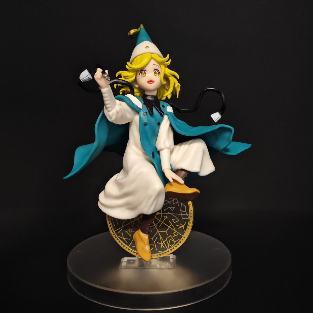 Alternate front view of Coco figurine with flowing teal cape and gold-patterned motif
