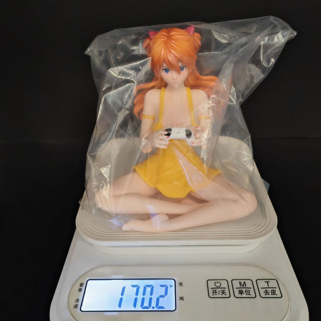 Seated Asuka figure inside clear bag packaging