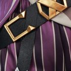 Angular gold buckle over purple-striped costume fabric