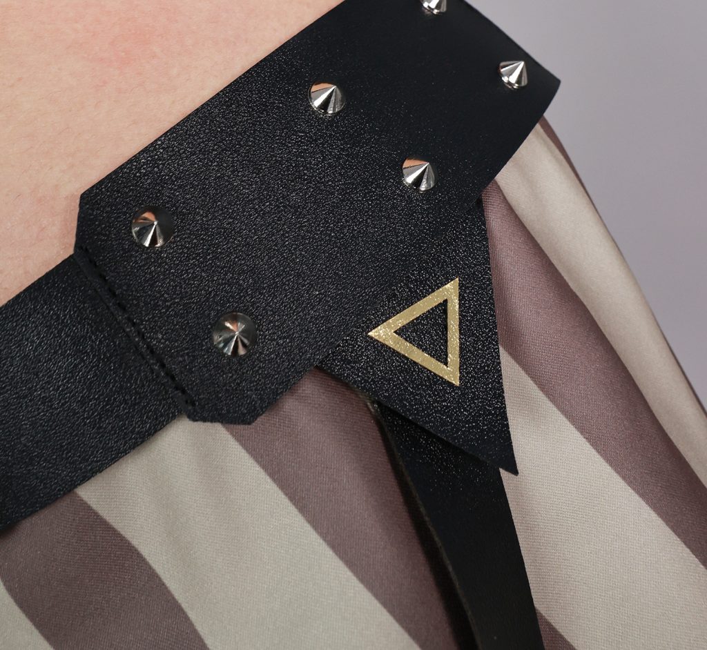 Black studded hip strap and gold triangular detail on Jinx costume
