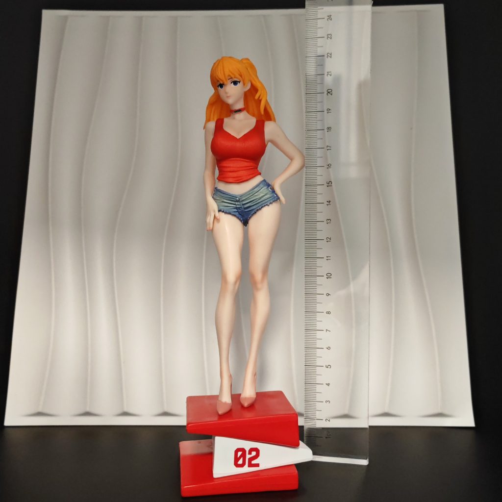 Asuka figurine with 02 base next to a ruler for scale context