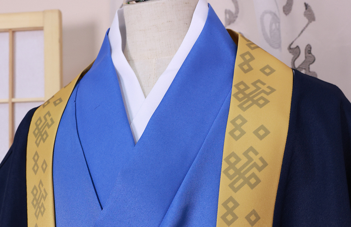 Blue inner layer and gold-trimmed navy outer robe at the neckline