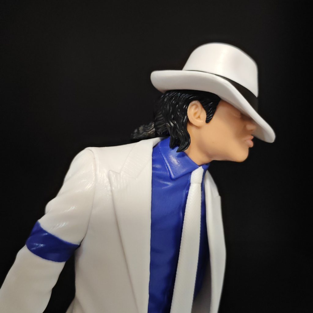 White suit figure detail showing fedora, blue shirt and jacket