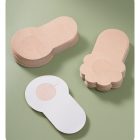 Light beige flower-shaped adhesive patch alongside circular example and protective backing