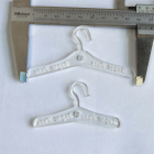 Clear miniature hangers shown beside a caliper for scale; caliper not included