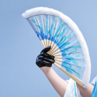 Blue-and-white PA-15 folding fan held in a black glove