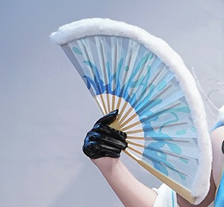 Photographed blue-and-white folding fan open in a black gloved hand
