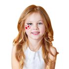 Heart and scroll cheek design made with face paint