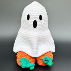 White crochet ghost cover over the orange pumpkin-accented novelty figure