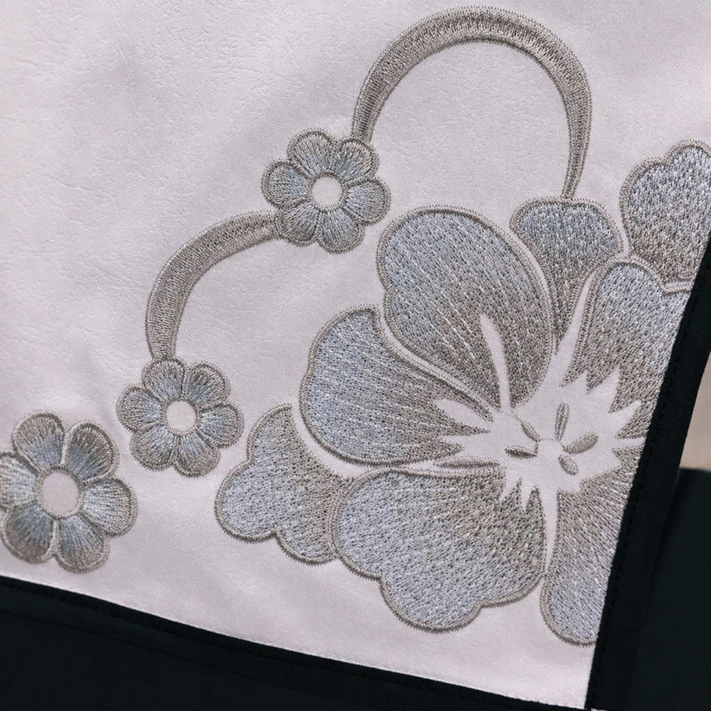 Silver floral embroidery and black piping on white costume fabric
