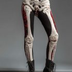 Cream bone-pattern leggings with black and red panels worn with boots