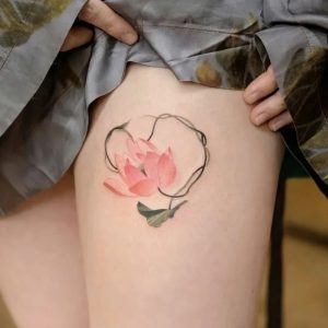 Pink lotus temporary tattoo with curved stem on upper thigh