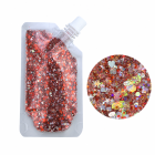 Red cosmetic glitter gel pouch and mixed-size glitter close-up