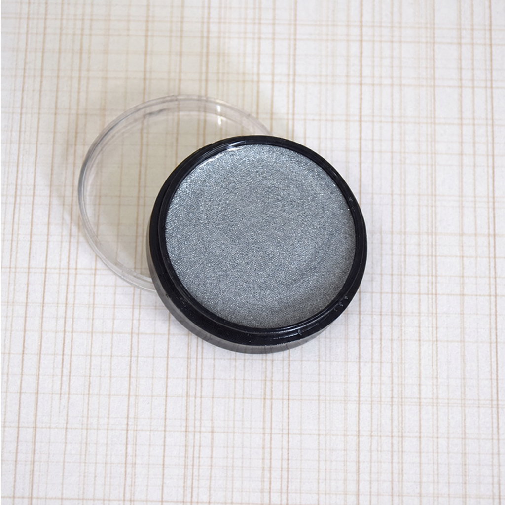 Silver metallic cosmetic paint in a round pot with clear lid