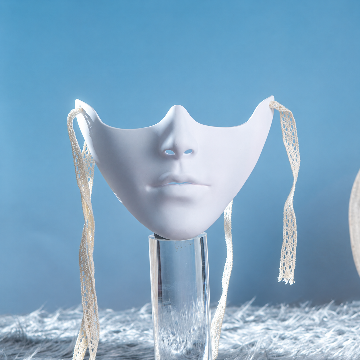 Smooth white lower-face mask with lace-like ties and plain chin
