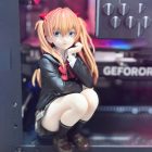 Wider view of crouching Asuka collectible figure in display setting; computer not included