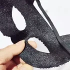 Reverse of cat mask with elastic band held in hand