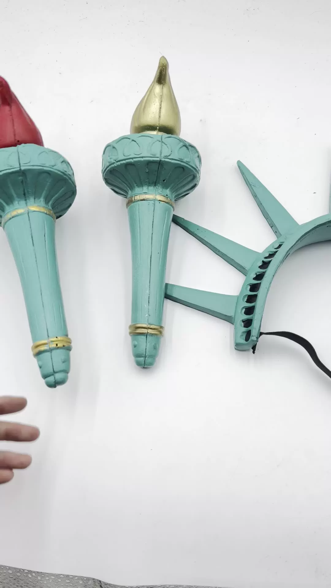 Close detail of red and gold torches beside seven-ray crown and elastic