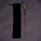 Reddish wand with mottled handle and black drawstring pouch