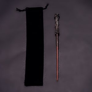 Reddish wand with rough dark handle beside black pouch