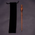 Forked brown wizard wand beside black drawstring pouch
