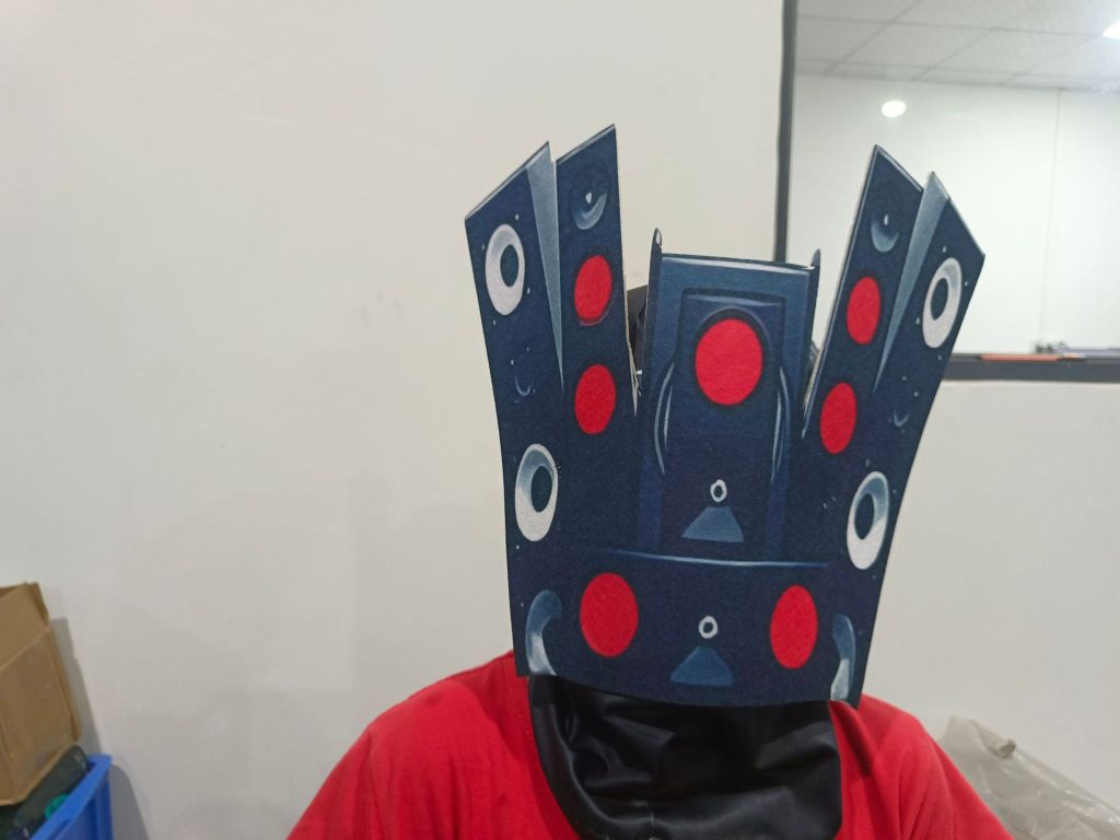 Speakerman printed head mask closeup with red and pale speaker circles