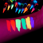 Face and body paint color swatches and pointed marker tips under UV light
