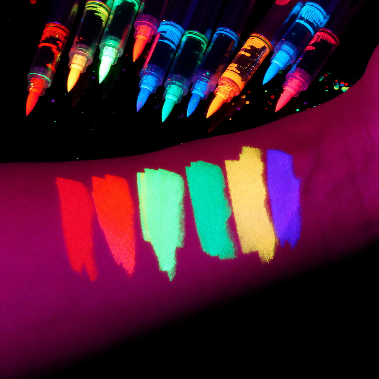 Face and body paint color swatches and pointed marker tips under UV light
